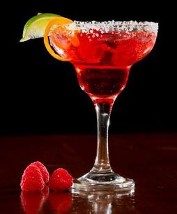 Raspberry Margarita in salted rim glass with lime and orange
