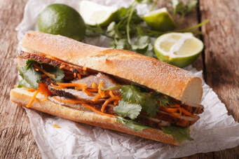 Pork Bahn Mi Sandwich with limes and cilantro in backgroundPicture