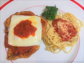 Chicken Parmesan, Pasta & Sauce on a plate with parsley garnish