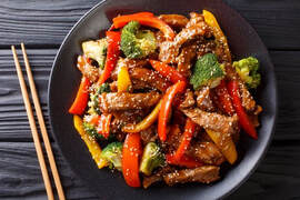 Wok-Fried Slippery Beef with Red Peppers & Broccoli on a black plate with chopsticksPicture