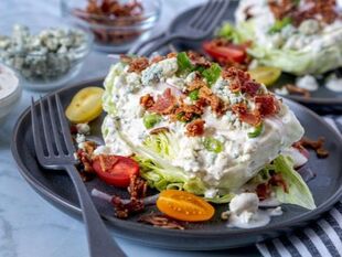 Iceberg Wedge Salad with blue cheese dressing, bacon, tomatoes & green onions