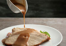 Gravy drizzle over a plate of roast turkey