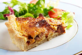 Slice of Quiche Lorraine on a plate with salad