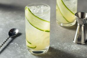 Cucumber Collins Cocktail with bar ware on a slab